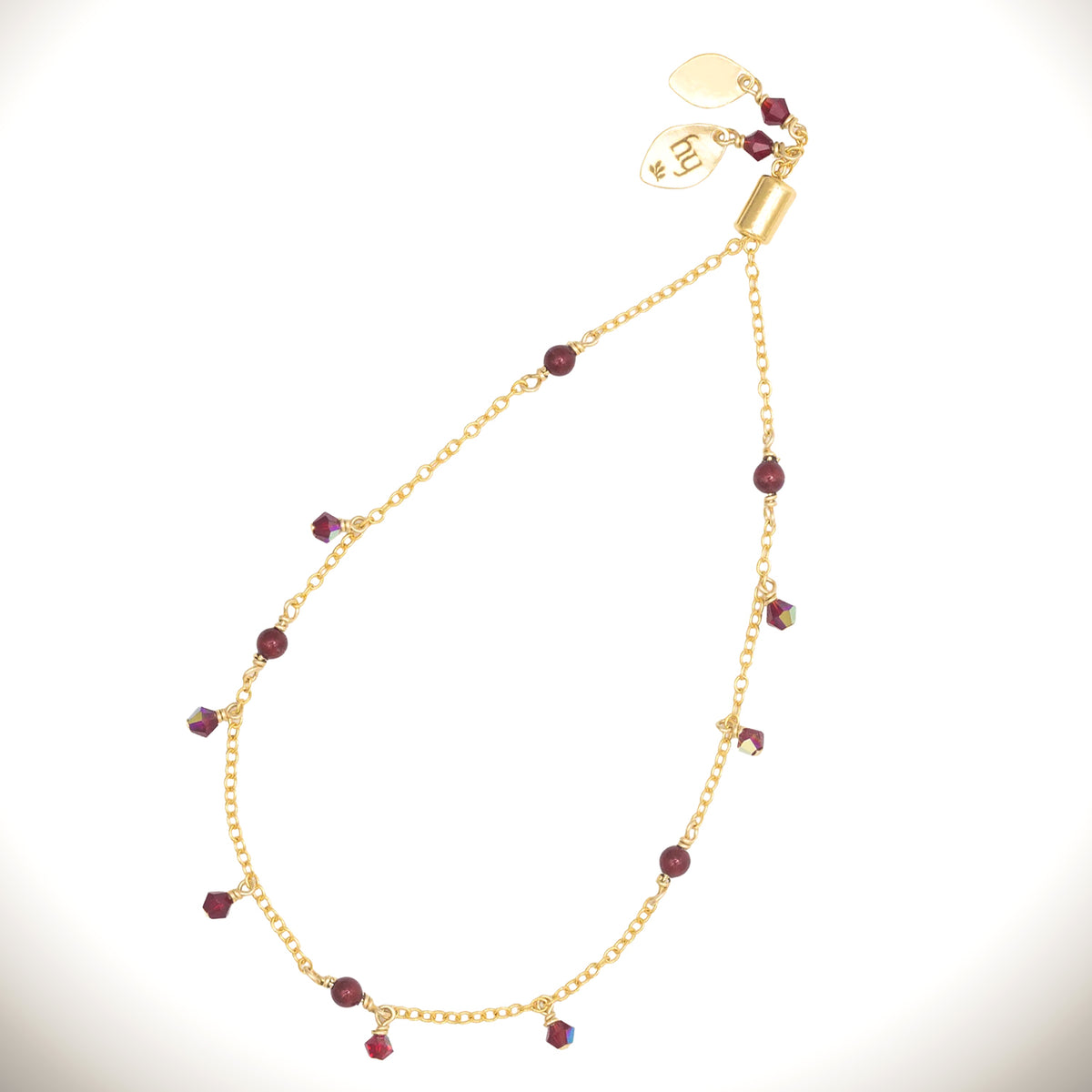 Holly Yashi Cora Pearl Bracelet with a gold-plated chain, cranberry-colored pearls, and small dangling faceted red beads on a white background.
