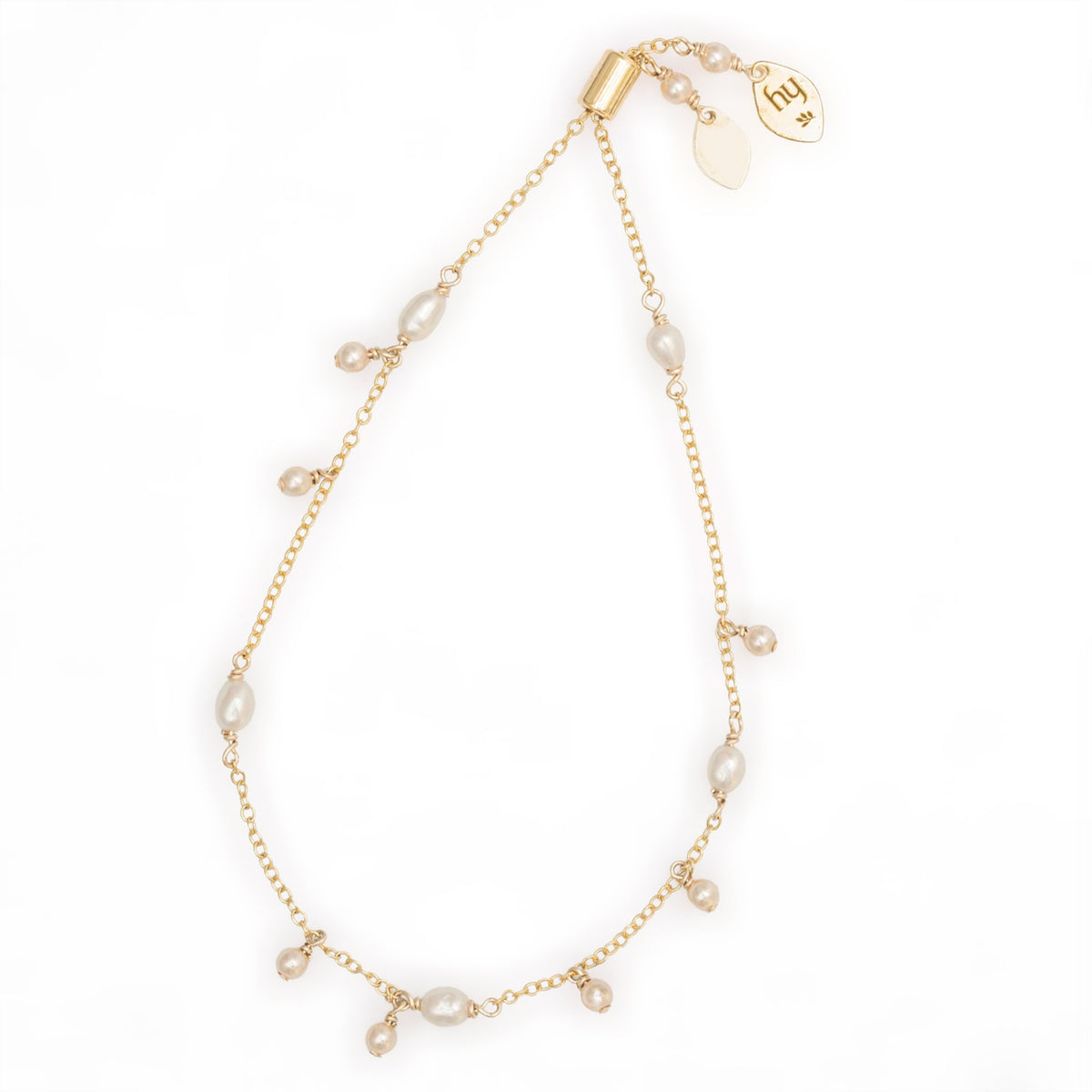 Holly Yashi Cora Pearl Bracelet in White/Gold with a delicate gold-plated chain, oval white pearls, and small dangling cream-colored bead accents.