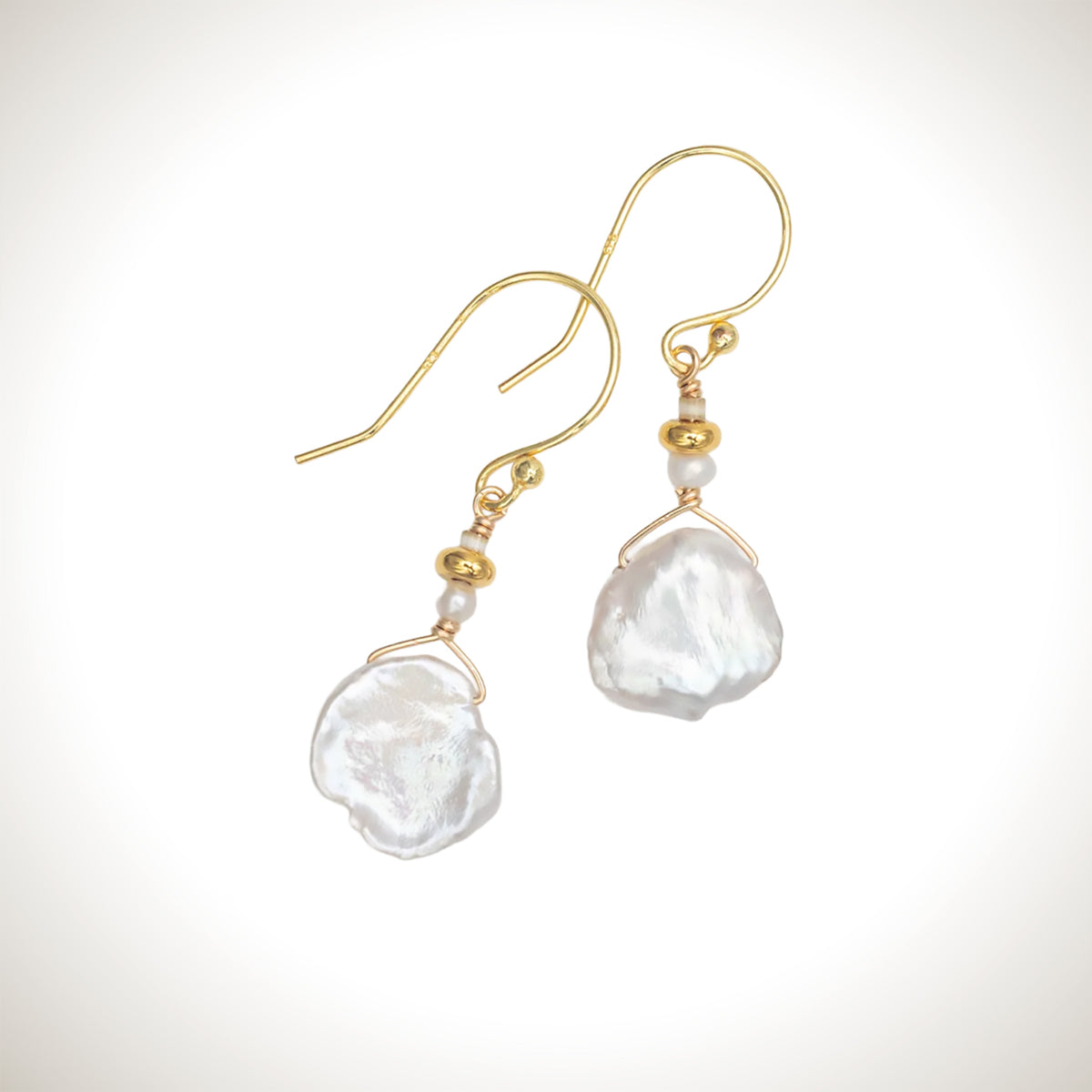 Holly Yashi Delicate Margo Cream/Gold earrings with irregular cream pearl drops, small glass bead accents, and gold-colored French hook ear wires.