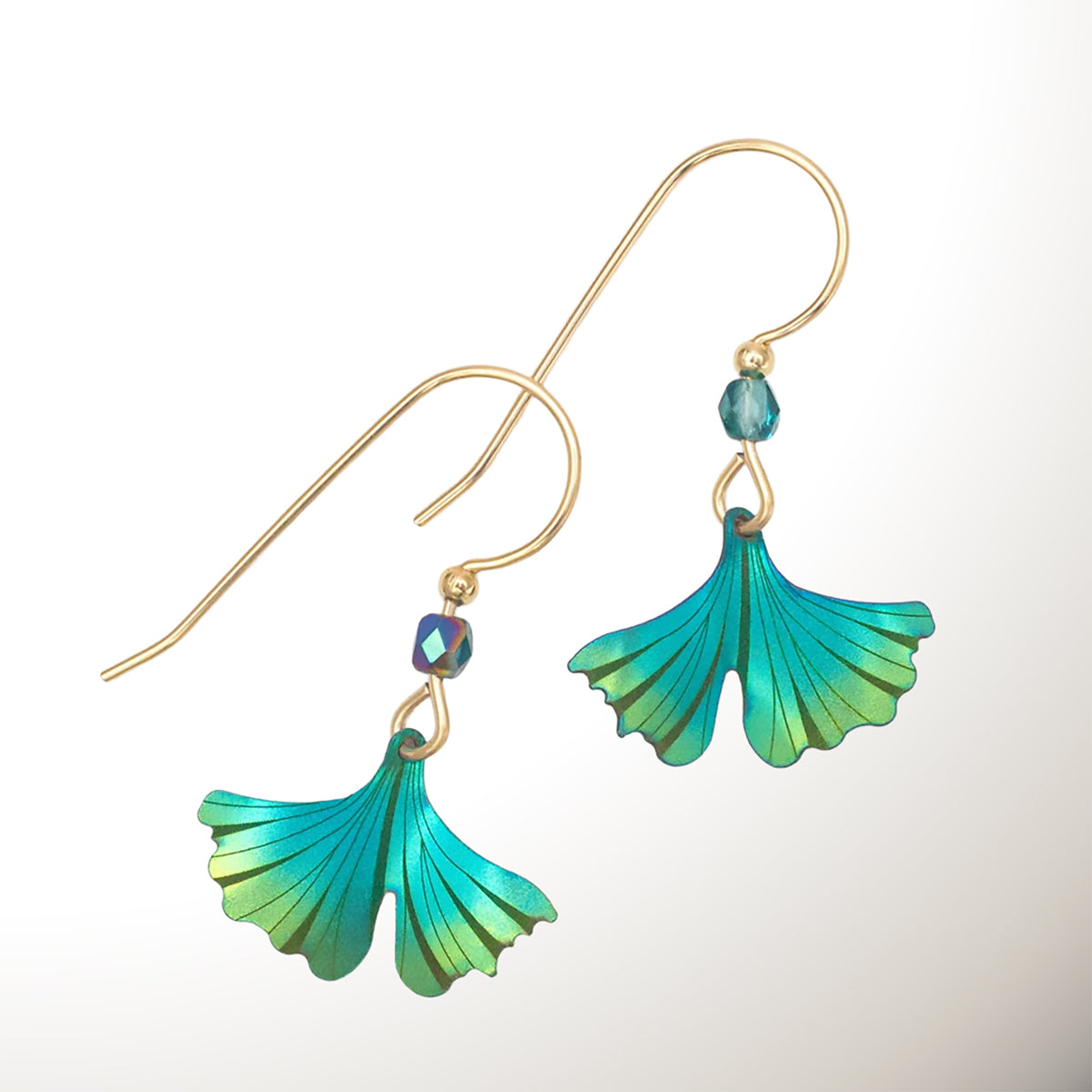 A pair of teal and turquoise-tone dangle earrings with gingko leaf-shaped leaf pendants, shown on a clean white background.